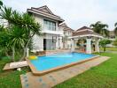 Exterior view of a house with a swimming pool and a garden