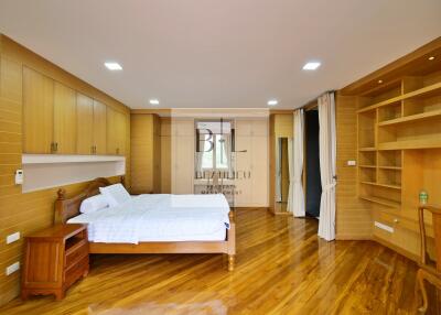 Spacious bedroom with wooden flooring and built-in storage