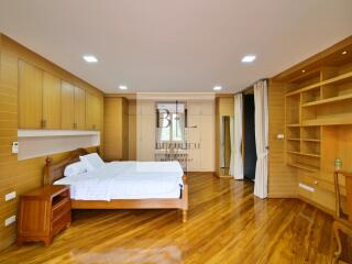 Spacious bedroom with wooden flooring and built-in storage