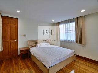 Bright bedroom with wooden floor and queen size bed