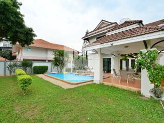 Exterior view of a residential house with a swimming pool and patio area