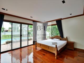 Spacious bedroom with wooden bed and large windows