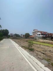 Vacant land with pathway and nearby residential buildings