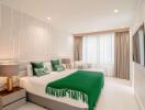 Modern bedroom with green accents and large window