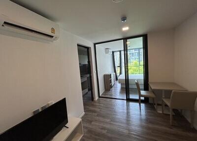 Modern living area with television, air conditioning, and view of balcony