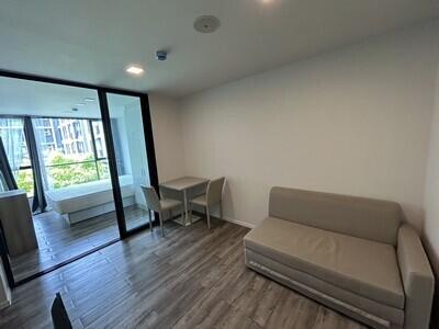 Modern living room with glass door opening to a bedroom