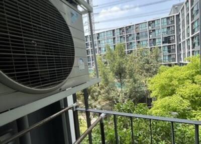 Balcony with a view of surrounding buildings and greenery