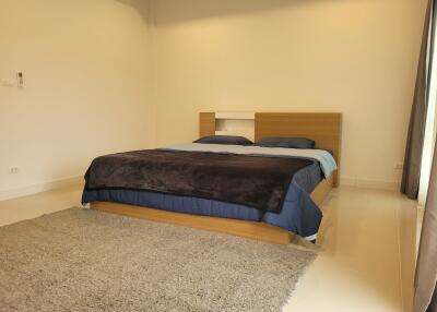 Modern bedroom with minimalist design featuring a wooden bed and cozy bedding