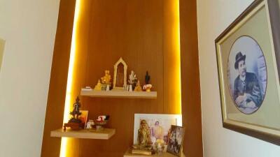 A living room with a lit wall shelf displaying various decor items and a framed picture