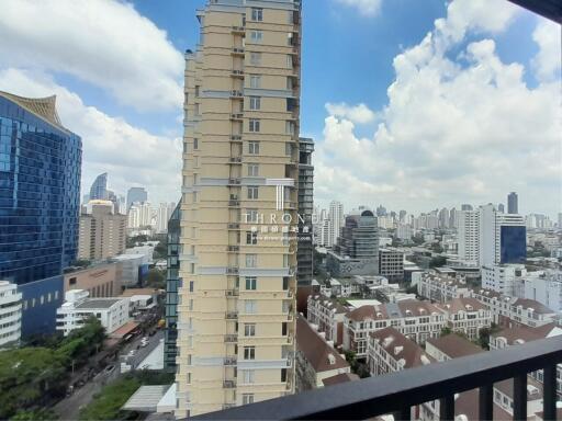 View from balcony overlooking city with tall buildings and residential area