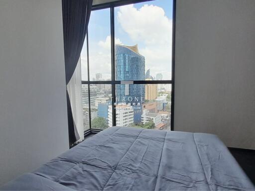 Bedroom with a view of the city through a large window