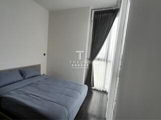 Modern bedroom with large window and grey bedding