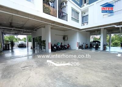 Parking area outside building with covered section and motorcycles