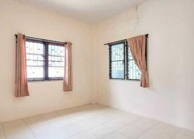 Bright empty bedroom with large windows and curtains