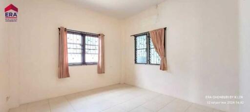 Bright empty bedroom with large windows and curtains