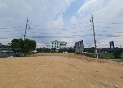 Empty plot of land with nearby building in the background