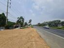 View of a road with some adjacent land and distant structures