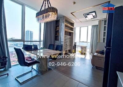 Modern dining and living area with large windows, marble table, and chandelier