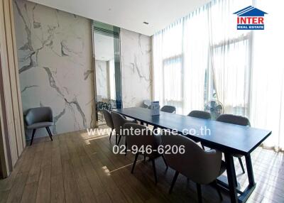 Modern dining area with large table, chairs, and natural light