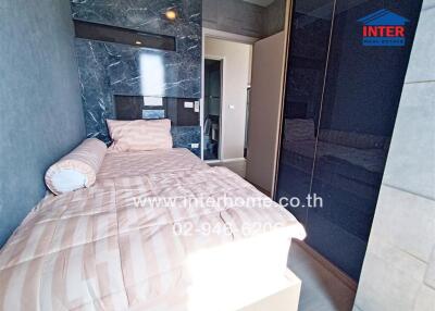 Bedroom with bed, wardrobe, and marble accent wall