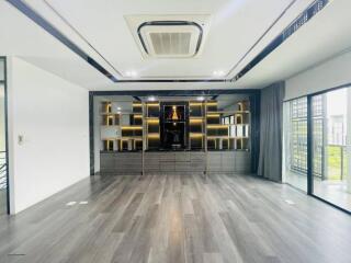 Spacious modern living room with large window and built-in shelving unit