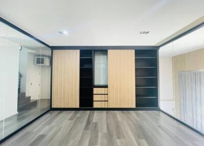 Spacious room with built-in wooden cabinets and shelves
