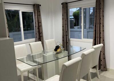 Modern dining room with glass table and white upholstered chairs