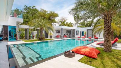 Modern luxury outdoor pool area with lounge chairs and palm trees