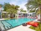 Modern luxury outdoor pool area with lounge chairs and palm trees