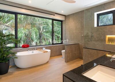 Spacious modern bathroom with large windows and a garden view