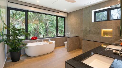 Spacious modern bathroom with large windows and a garden view