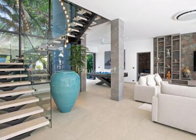 Modern living room with glass staircase and large ceramic vase