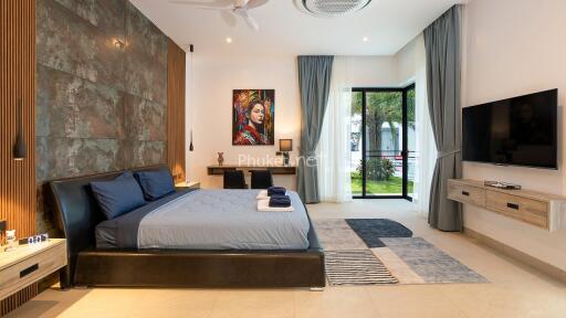 Modern bedroom with large bed, wall art, and TV