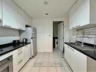 Modern kitchen with white cabinets and appliances.