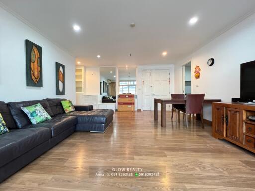 Modern living room with wooden flooring and black L-shaped sofa