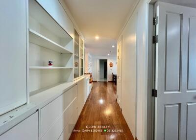 Bright hallway with built-in shelving and hardwood floors