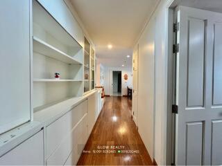 Bright hallway with built-in shelving and hardwood floors