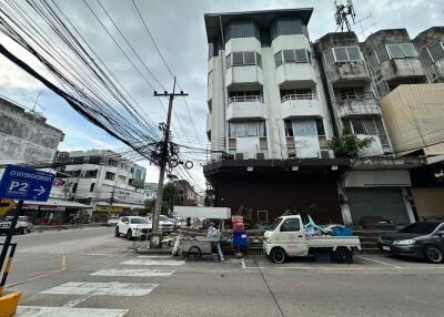 Exterior view of a commercial building with parked vehicles and street view