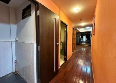 Illuminated hallway with wooden flooring and orange walls