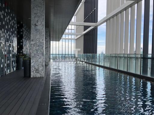 Modern indoor swimming pool with glass walls and city view