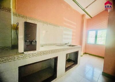 A simple kitchen with tiled countertops and a water dispenser.