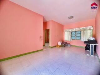 Empty living room with pink walls and a tiled floor