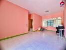 Empty living room with pink walls and a tiled floor