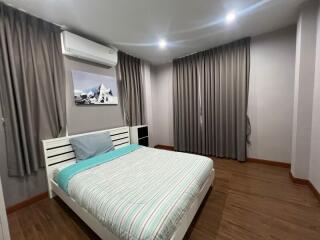 Modern bedroom with an air conditioner and artwork above the bed