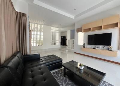 Modern living room with black leather sofa and wall-mounted TV