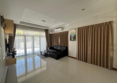 Well-lit living room with large windows and modern furnishings