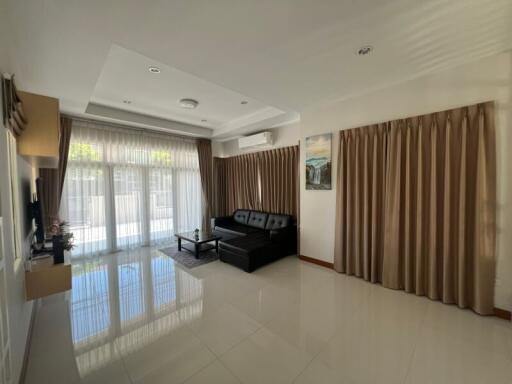 Well-lit living room with large windows and modern furnishings