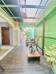 Covered patio area with wooden furniture