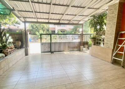 Spacious covered outdoor patio with tiled floor and garden view