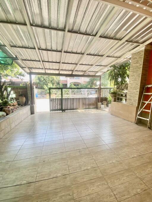 Spacious covered outdoor patio with tiled floor and garden view